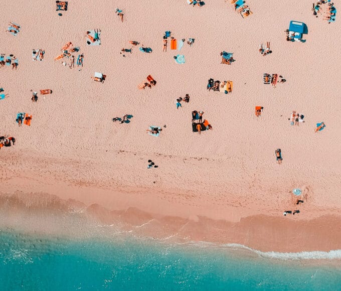 Massentourismus am Strand, Drohnen-Aufnahme von vielen Menschen am Strand liegend