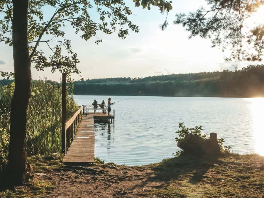 Kinder spielen auf einem Steg an einem See in Mecklenburg-Vorpommern, aus dem Nebel aufsteigt