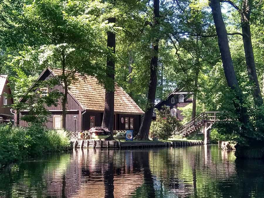 Historische Holzhäuser am Ufer eines Kanals im Spreewald