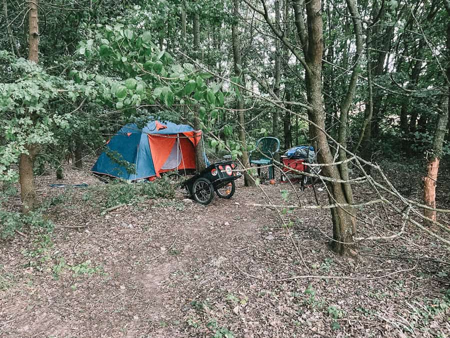 Obdachloser im Schutzgebiet im Wald mit Fahrrad, Anhänger