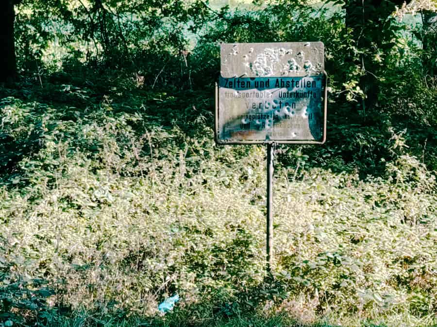Verrottetes Schild im Landschaftsschutzgebiet Zelten verboten