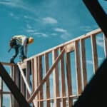 Ein Mann auf einer Holzkonstruktion sehr gefährlich - Situation in den Golfstaaten mit problematischen Arbeitsbedingungen