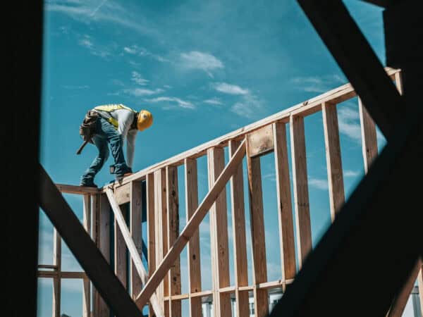 Ein Mann auf einer Holzkonstruktion sehr gefährlich - Situation in den Golfstaaten mit problematischen Arbeitsbedingungen