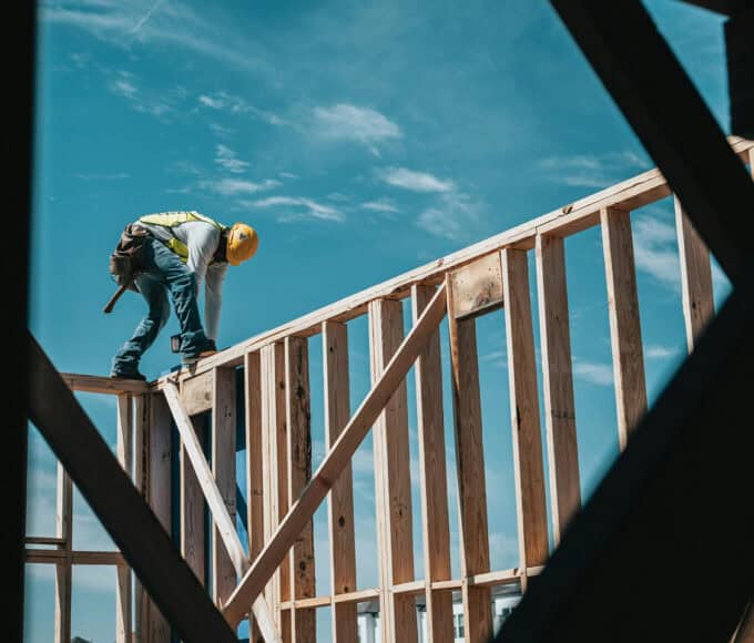 Ein Mann auf einer Holzkonstruktion sehr gefährlich - Situation in den Golfstaaten mit problematischen Arbeitsbedingungen