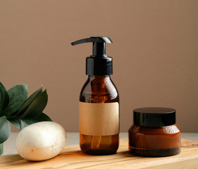 Braune Naturkosmetik-Flaschen und Creme auf Holzbrett