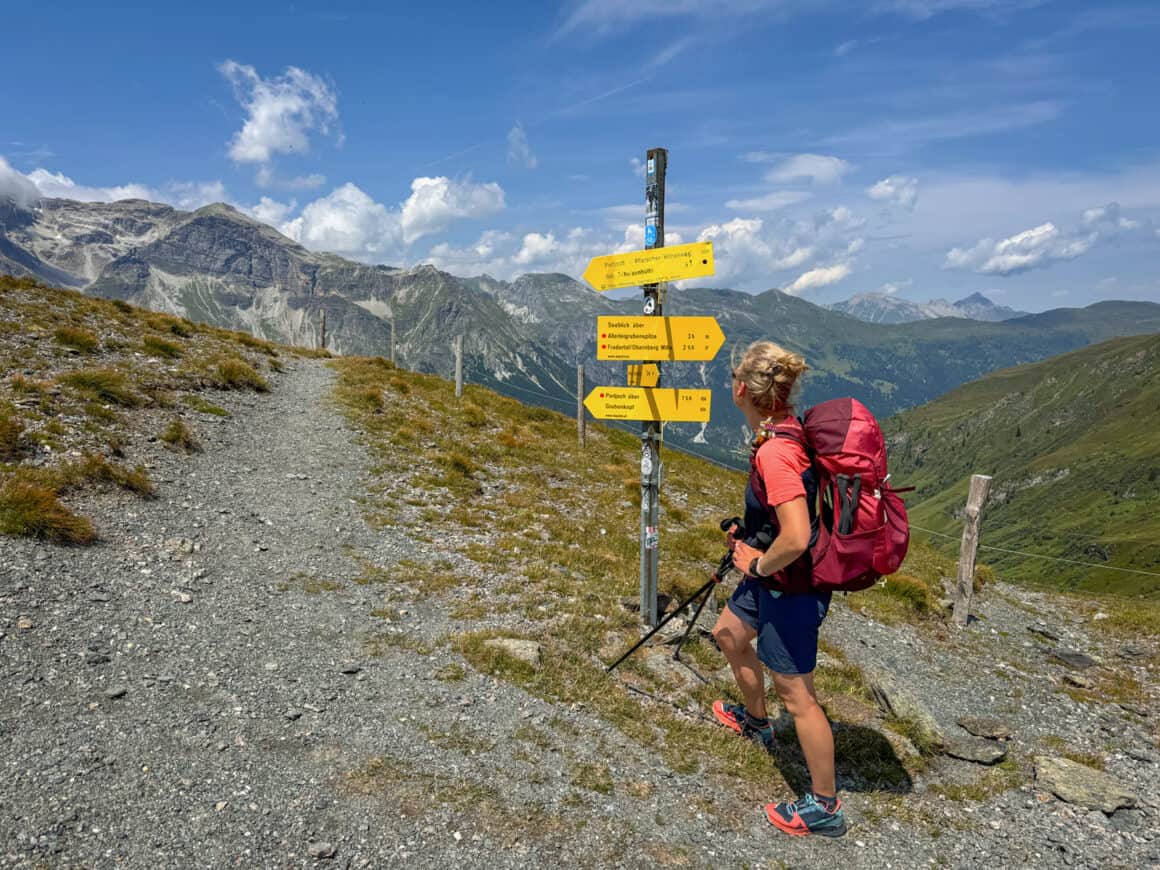 Wanderin an einem Wegweiser beim Wandern in den Alpen Richtung Obernberg